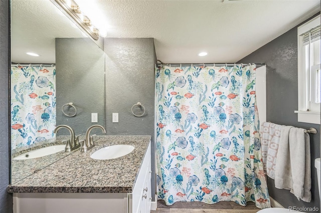 524 N 4th Ave, Sterling, CO 80751 - full bathroom with a textured wall, vanity, a shower with curtain, and a textured ceiling