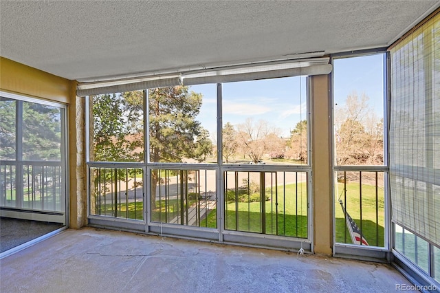 3022 S Wheeling Way Unit 205, Aurora, CO 80014 - unfurnished sunroom featuring baseboard heating, a textured ceiling, concrete floors, and expansive windows