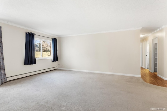 spare room with a baseboard heating unit, carpet, crown molding, and baseboards