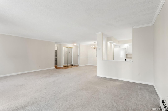 empty room with a textured ceiling, a baseboard heating unit, light carpet, ornamental molding, and an inviting chandelier