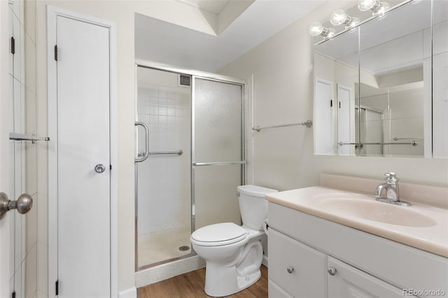 full bath with a stall shower, visible vents, toilet, wood finished floors, and vanity