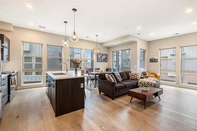 living area with light wood-type flooring, visible vents, and recessed lighting