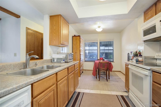 kitchen featuring light tile patterned flooring, white appliances, and sink