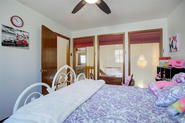 bedroom with ceiling fan with notable chandelier