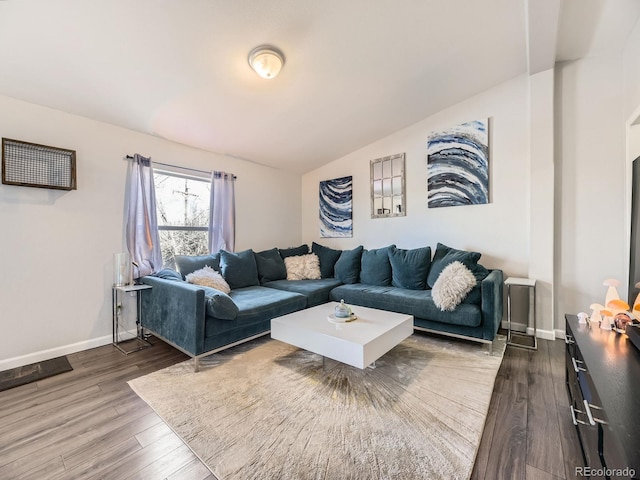 living room featuring baseboards, vaulted ceiling, and wood finished floors