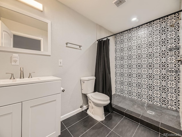 bathroom featuring tile patterned flooring, toilet, vanity, visible vents, and a tile shower