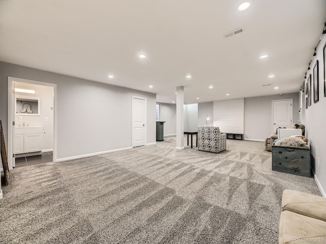 carpeted living area featuring recessed lighting, visible vents, and baseboards