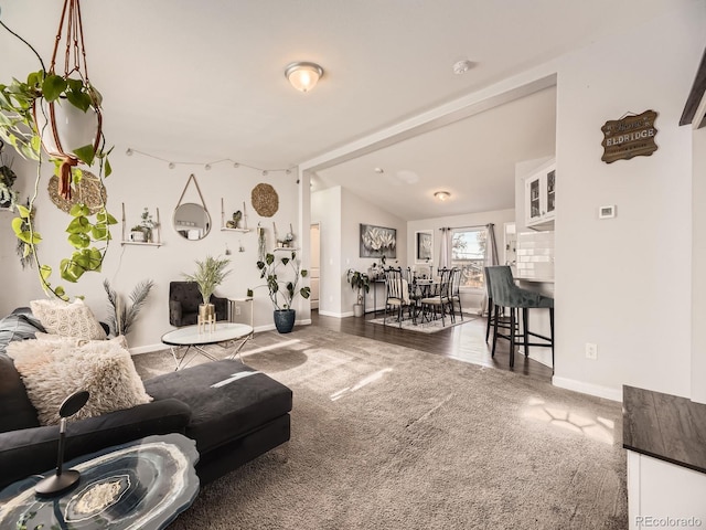 carpeted living room with vaulted ceiling and baseboards