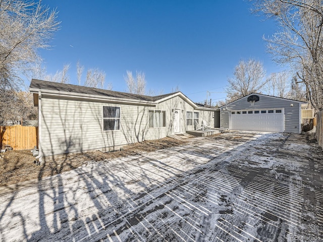 view of front of house with a detached garage, fence, and an outdoor structure