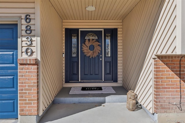 property entrance with a garage and brick siding