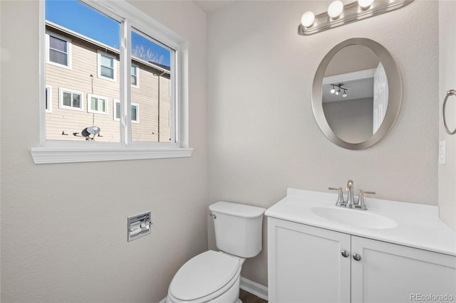 bathroom featuring vanity, toilet, and plenty of natural light