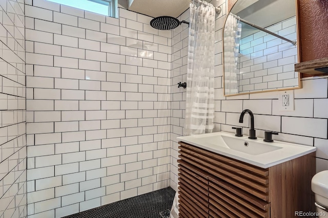 2310 Kenton St, Aurora, CO 80010 - full bath with tiled shower, vanity, and tile walls