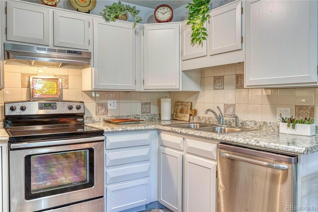 13609 E Cornell Ave Unit 107, Aurora, CO 80014 - kitchen featuring tasteful backsplash, white cabinetry, appliances with stainless steel finishes, under cabinet range hood, and a sink