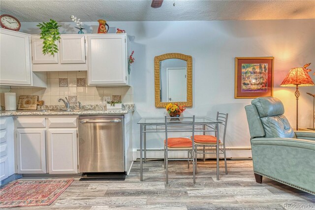 kitchen with dishwasher, tasteful backsplash, light wood-type flooring, and white cabinetry