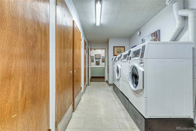 13609 E Cornell Ave Unit 107, Aurora, CO 80014 - shared laundry area with baseboards, separate washer and dryer, and a textured ceiling