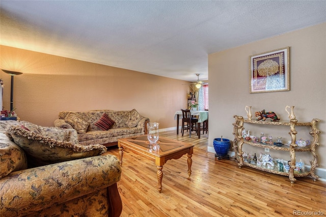 living room with ceiling fan and light hardwood / wood-style flooring