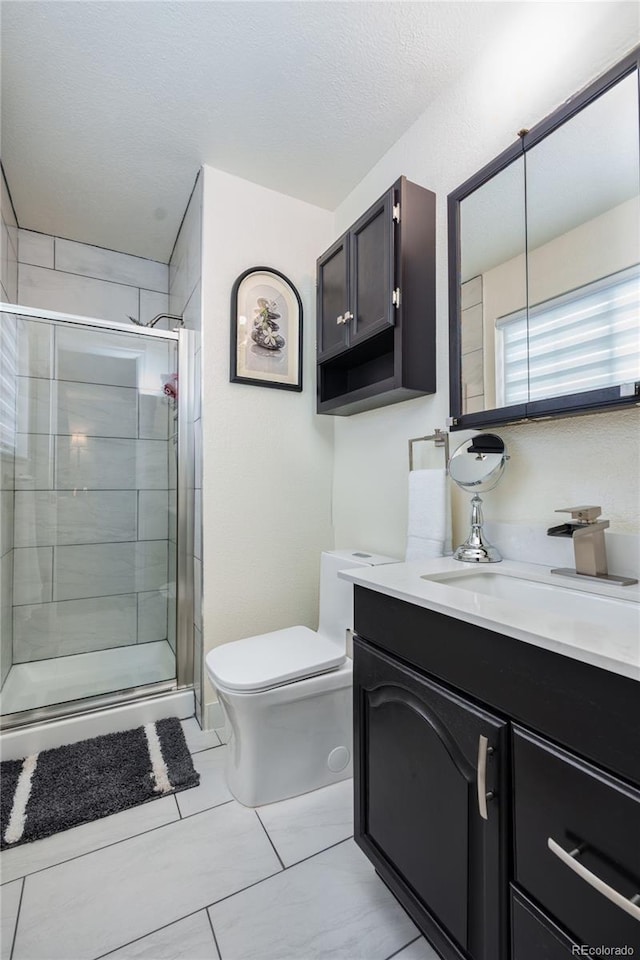 bathroom featuring a textured ceiling, toilet, vanity, and an enclosed shower