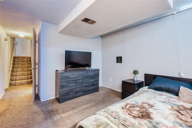 bedroom featuring carpet and a textured ceiling