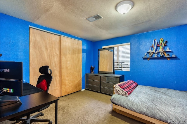 carpeted bedroom with a textured ceiling and a closet