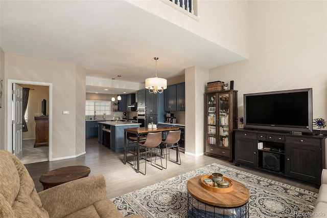 living room with an inviting chandelier and light wood-type flooring