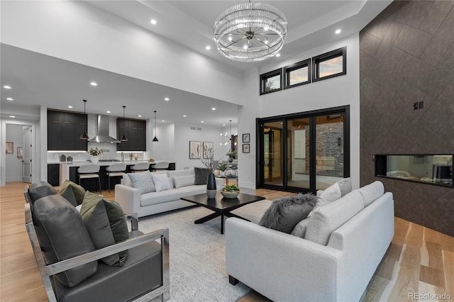 8103 Raphael Ln, Littleton, CO 80125 - living area with light wood finished floors, a chandelier, recessed lighting, and a towering ceiling
