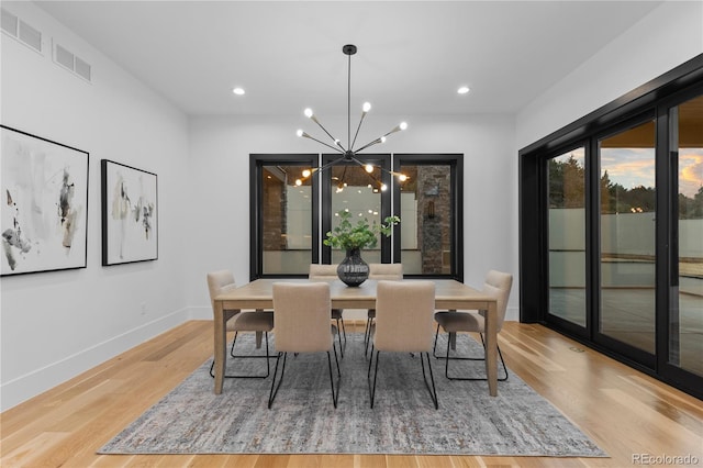 8103 Raphael Ln, Littleton, CO 80125 - dining area with baseboards, a chandelier, visible vents, and wood finished floors