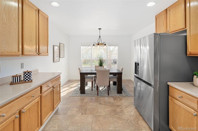 kitchen with stainless steel fridge, light countertops, recessed lighting, and an inviting chandelier