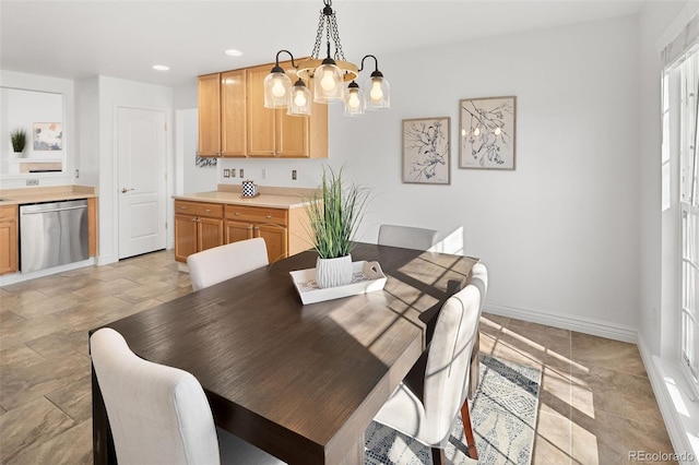dining area featuring baseboards, stone finish floor, recessed lighting, and a chandelier