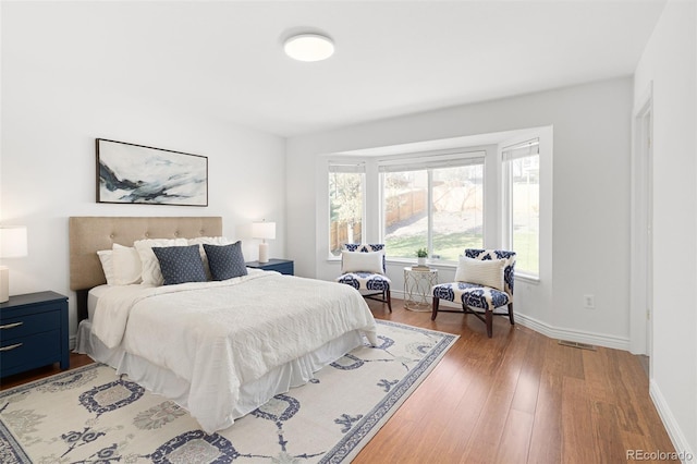 bedroom with light wood-style floors, baseboards, and visible vents