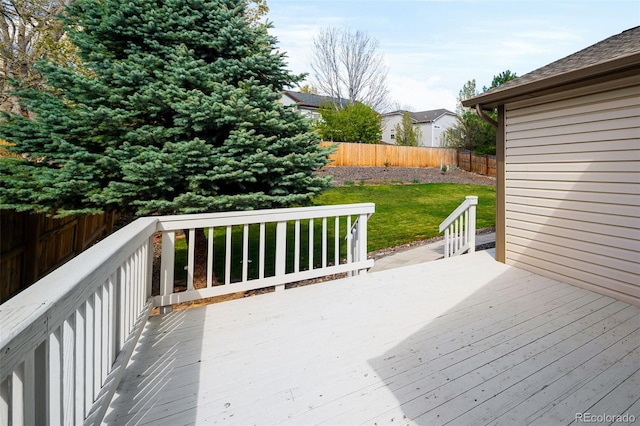 wooden terrace with a lawn and a fenced backyard