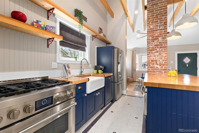 kitchen with open shelves, a sink, wooden counters, blue cabinets, and stainless steel appliances