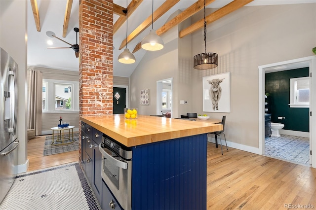 kitchen featuring wooden counters, beamed ceiling, light wood finished floors, blue cabinetry, and appliances with stainless steel finishes