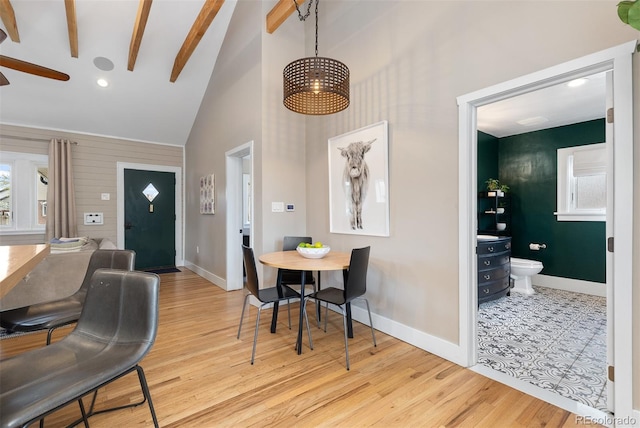 interior space with high vaulted ceiling, baseboards, and wood finished floors