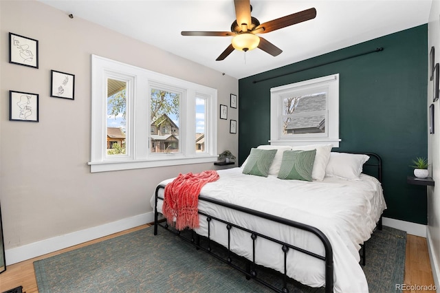 bedroom with baseboards, a ceiling fan, and wood finished floors