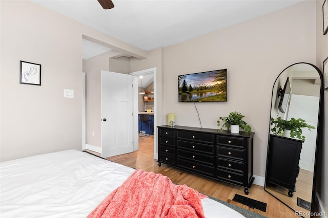 bedroom featuring a ceiling fan, baseboards, and light wood-style floors