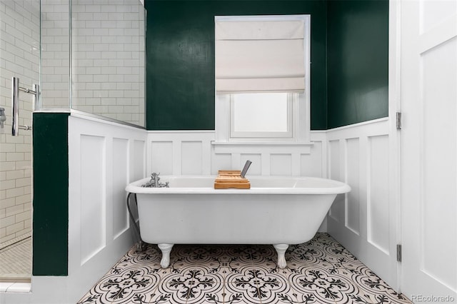 full bathroom with a decorative wall, a wainscoted wall, and a stall shower