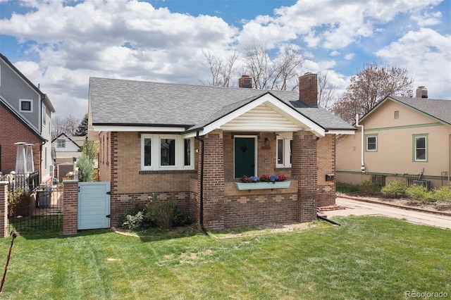 bungalow featuring brick siding, a chimney, and a front yard