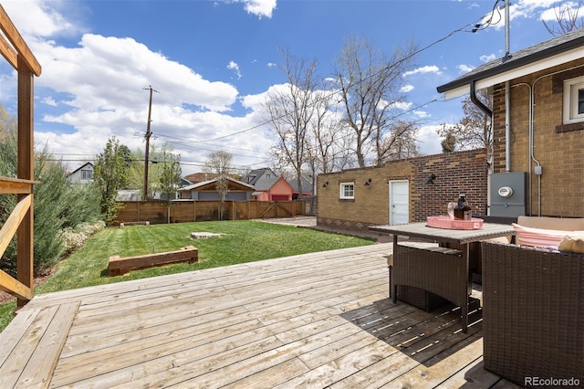 wooden terrace with a yard, outdoor dining area, and a fenced backyard