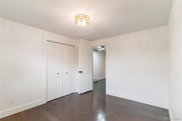 6581 E Heritage Pl, Englewood, CO 80111 - unfurnished bedroom with a chandelier, dark wood finished floors, and a closet