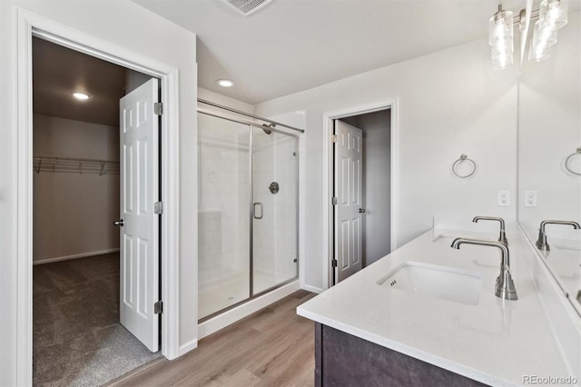 bathroom with vanity, a shower with door, and hardwood / wood-style floors