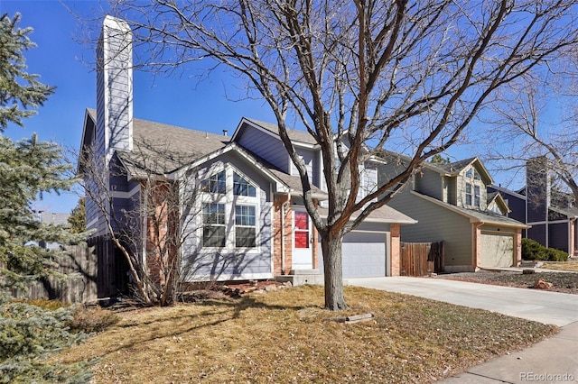 traditional home featuring brick siding, a chimney, concrete driveway, fence, and a garage