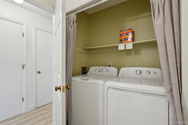 washroom featuring laundry area, independent washer and dryer, and light wood-style floors