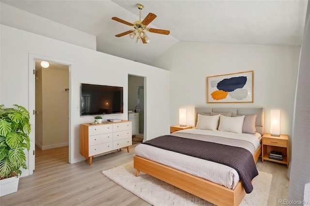 bedroom with light wood-style floors, connected bathroom, vaulted ceiling, and a ceiling fan