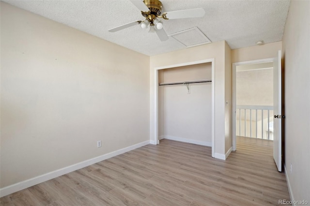 unfurnished bedroom featuring baseboards, a textured ceiling, and light wood finished floors