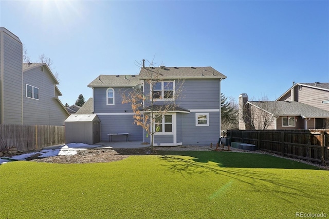 back of house with an outbuilding, a yard, a patio, a shed, and a fenced backyard