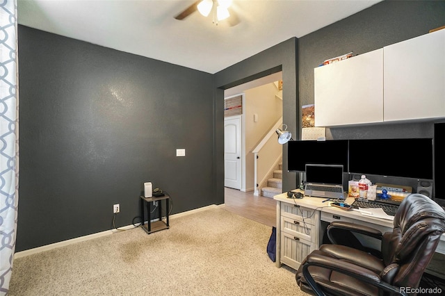 carpeted office space with ceiling fan