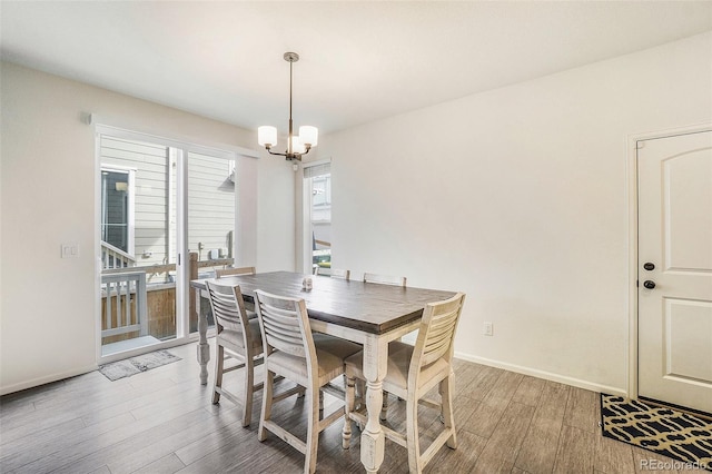 dining room with wood-type flooring and an inviting chandelier