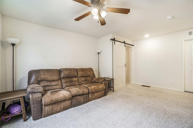 living room with light carpet, a barn door, and ceiling fan