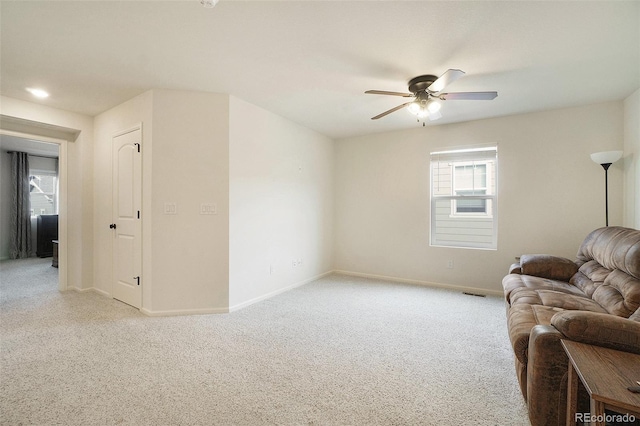 carpeted living room with ceiling fan