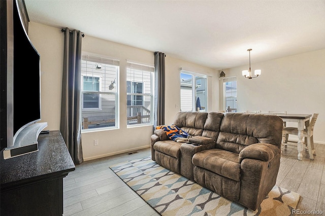 living room featuring a notable chandelier and light hardwood / wood-style flooring